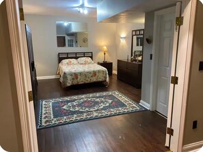 A bedroom with a bed, dresser, nightstand, and a rug. - Broad Ripple Retreat | Private Gym & Yard (Indianapolis)