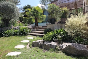 A garden with a stone pathway, large rocks, and various plants. - Air-conditioned villa with heated pool - Golf de Pont-Royal - 6 pers (Mallemort)