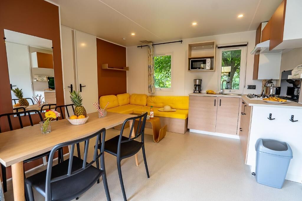 Eine moderne Küche mit Essbereich, einer Couch und einem kleinen Fenster.