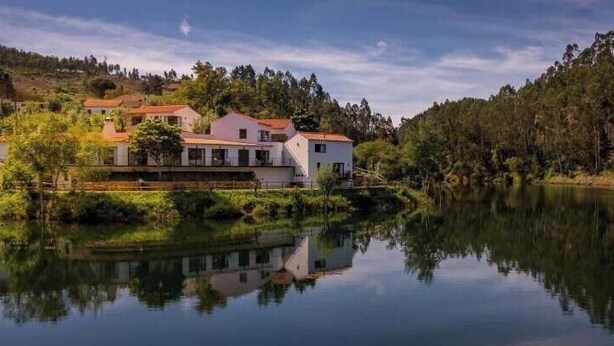 A lakeside property with a white building, a dock, and surrounding greenery. - Jacques de Molay Suite with balcony and river view (Dornes)