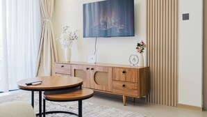 Un salon moderne doté d’un téléviseur à écran plat, de meubles en bois et d’objets décoratifs.