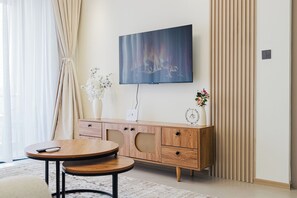 Ein modernes Wohnzimmer mit Flachbildfernseher, Holzmöbeln und Dekorationselementen.