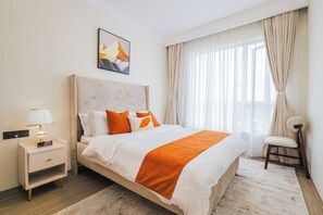 Ein Hotelzimmer mit einem großen Bett, einem Nachttisch mit Lampe, einem Sessel und einem Bild an der Wand.