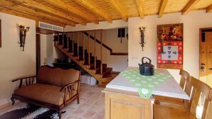 A wooden interior with a staircase, a dining table with chairs, and a sofa. - D.Nuno Álvares Pereira House - balcony and river view (Dornes)