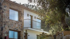 Un edificio de piedra de dos pisos con un balcón, una puerta y una ventana.