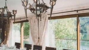 A dining room with a long table set for a meal, large windows, and a chandelier. - Ordem de Cristo Suite - Rural Tourism with terrace and river view (Dornes)
