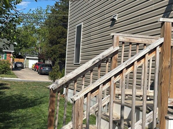 A residential house with a wooden staircase leading to a porch.