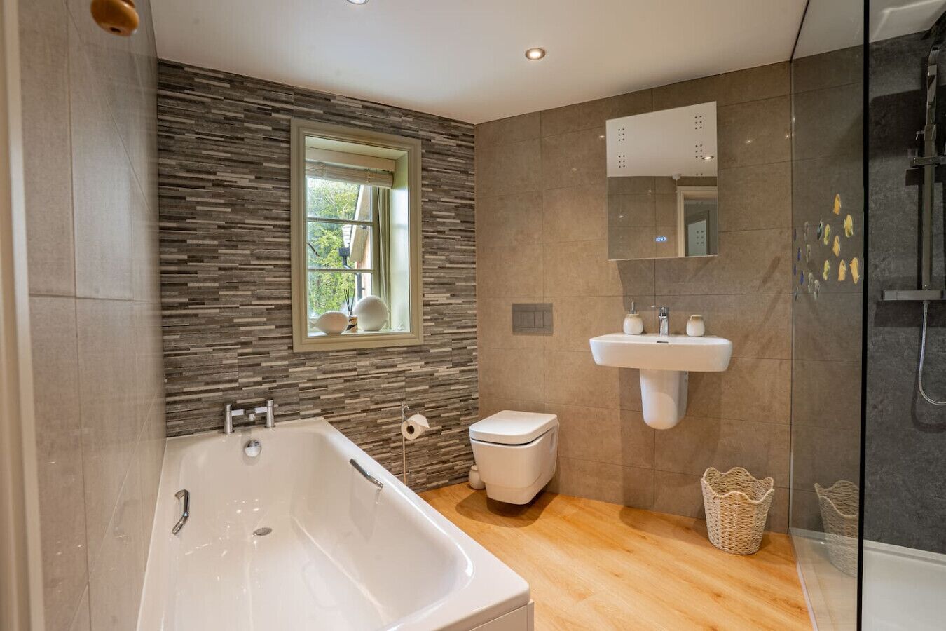 A modern bathroom with a freestanding bathtub, a toilet, a sink, and a shower.