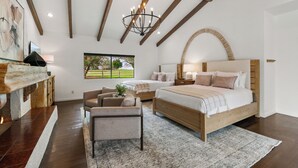 A bedroom with a large bed, a seating area, a fireplace, and a view of the outdoors. - 20 Beds, 2 Pickleball Courts, Basketball, 4 Acres,
Gym and Gameroom (Bermuda Dunes)