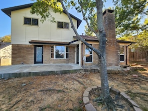 A two-story house with a brick exterior, a front porch, and a tree in the yard. - <8mi FIFAWorldCup Arlington CowBoysATT GlobeLife TexasRangers SixFlags Free Park (Arlington)