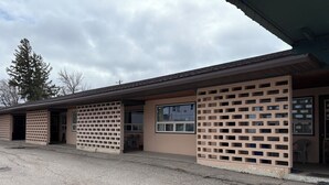 A building with a brick facade, multiple windows, and a flat roof. - Casey's Inn (Lac du Bonnet)