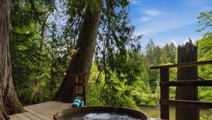 A wooden deck with a hot tub, surrounded by trees and a wooden fence. - Burke Bay A-Frame Retreat w/Cedar Hot Tub - 15 Minutes to Seattle Ferry (Bremerton)