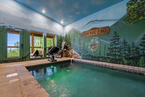 Uma área de piscina com um mural, um deck de madeira e uma placa que diz 'Love Nest Lodge'.