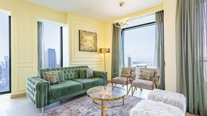 Uma sala de estar moderna com um sofá verde, uma mesa de centro de vidro e vista para a cidade.