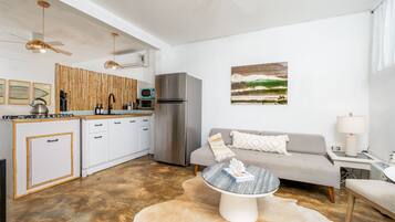 A modern kitchen with white cabinets, a stainless steel refrigerator, and a bamboo wall.