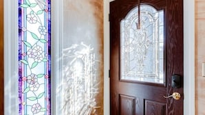 Un rincón con una puerta de madera y un ventanal de vitral.