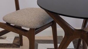 A chair with a cushioned seat and a round table with a dark surface. - Bambagina Mare (Amalfi)