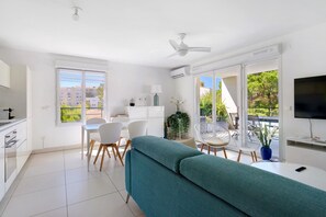 Un appartement moderne doté d’une cuisine, d’un coin repas et d’un balcon.