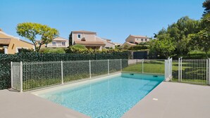 A rectangular swimming pool with a white fence, surrounded by a paved patio. - Cap Sud, Antibes – Quiet 2-Bedroom, Pool, Parking (Antibes)
