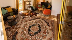 A living room with a sofa, armchairs, a coffee table, a rug, and a chandelier. - Bern Garten Residence 152m Luxury Apartment (Bern)