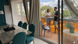 Un interior moderno con comedor, un balcón con vistas y un ventanal corredera.