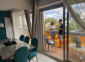 Ein modernes Interieur mit Essbereich, einem Balkon mit Aussicht und einer Schiebeglasdoor.