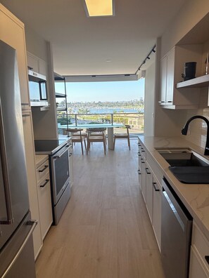 Eine moderne Küche mit Blick auf eine Marina, ausgestattet mit Einbaugeräten und einem Essbereich mit Tisch und Stühlen.