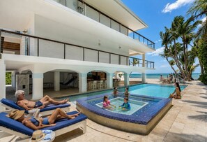 A resort with a swimming pool, lounge chairs, and a view of the ocean. - Southwind Private Beachfront Estate with Infinity Pool, Spa and Fishing Pier (Islamorada)