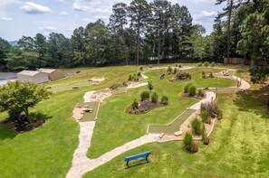 A well-maintained outdoor area with a lawn, pathways, and a small water feature. - Family Friendly 3BR/3BA w/ Pools, Pickleball, Putt Putt and Much More! (Hot Springs)