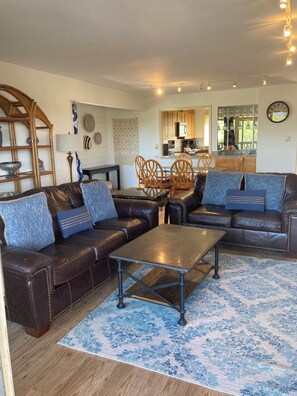 A living room with a brown leather sofa set, a coffee table, and a patterned rug. - Family Friendly 3BR/3BA w/ Pools, Pickleball, Putt Putt and Much More! (Hot Springs)