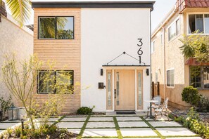A modern two-story house with a wooden facade, a central door with glass panels, and a number '361' above it. - Chic Designer Home, Walkable to Marine Stadium and Minutes to Beach & 2nd Street (Long Beach)