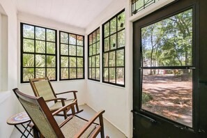 A room with large windows, a wooden chair, and a small table. - Large Updated Home/Close to Campus/Heart of Gville (Gainesville)