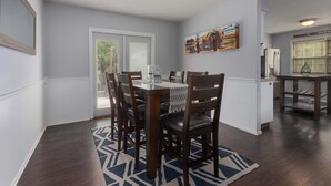 A dining area with a table, chairs, and a rug. - Family Favorite_Sleeps 8_Roomy_Game Room (Lenexa)