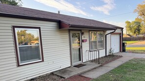 A single-story house with a front porch, a garage door, and a mailbox.