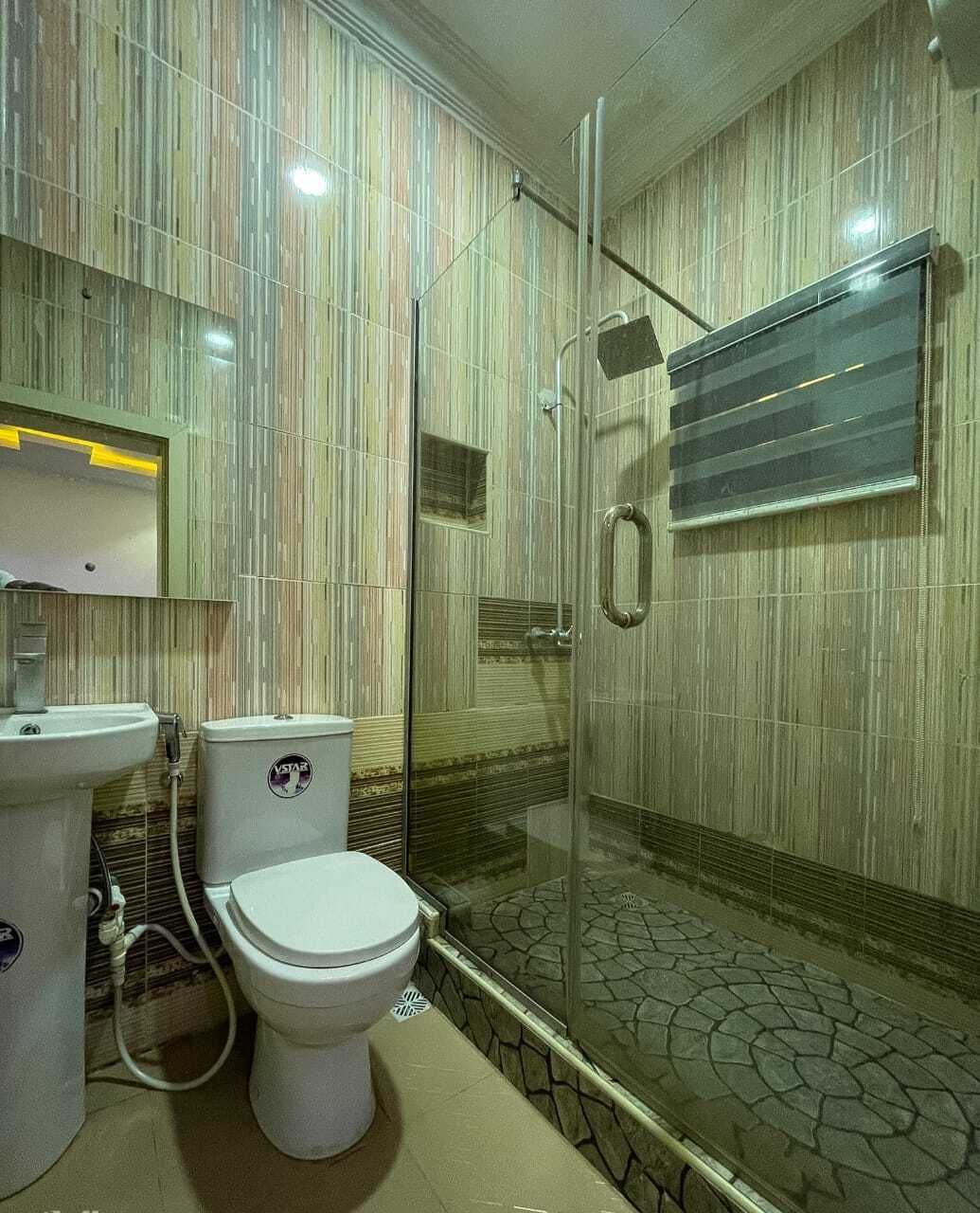 A bathroom with a toilet, sink, and shower area.