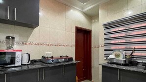 Una cocina con armarios oscuros, microondas, tostadora y estufa.