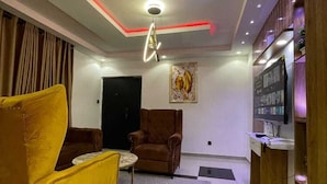Una sala de estar moderna con un sofá, un sillón y una mesita.