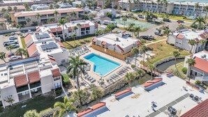 A resort with a swimming pool, multiple buildings, and a view of the ocean. - Runaway Bay 276 by Duncan Real Estate (Bradenton Beach)