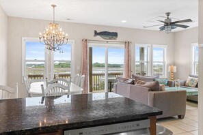 A spacious kitchen with a granite countertop, a chandelier, and a ceiling fan. - Jolly Rogers: Oceanview, Walk to Beach, Sleeps 12 (Surf City)