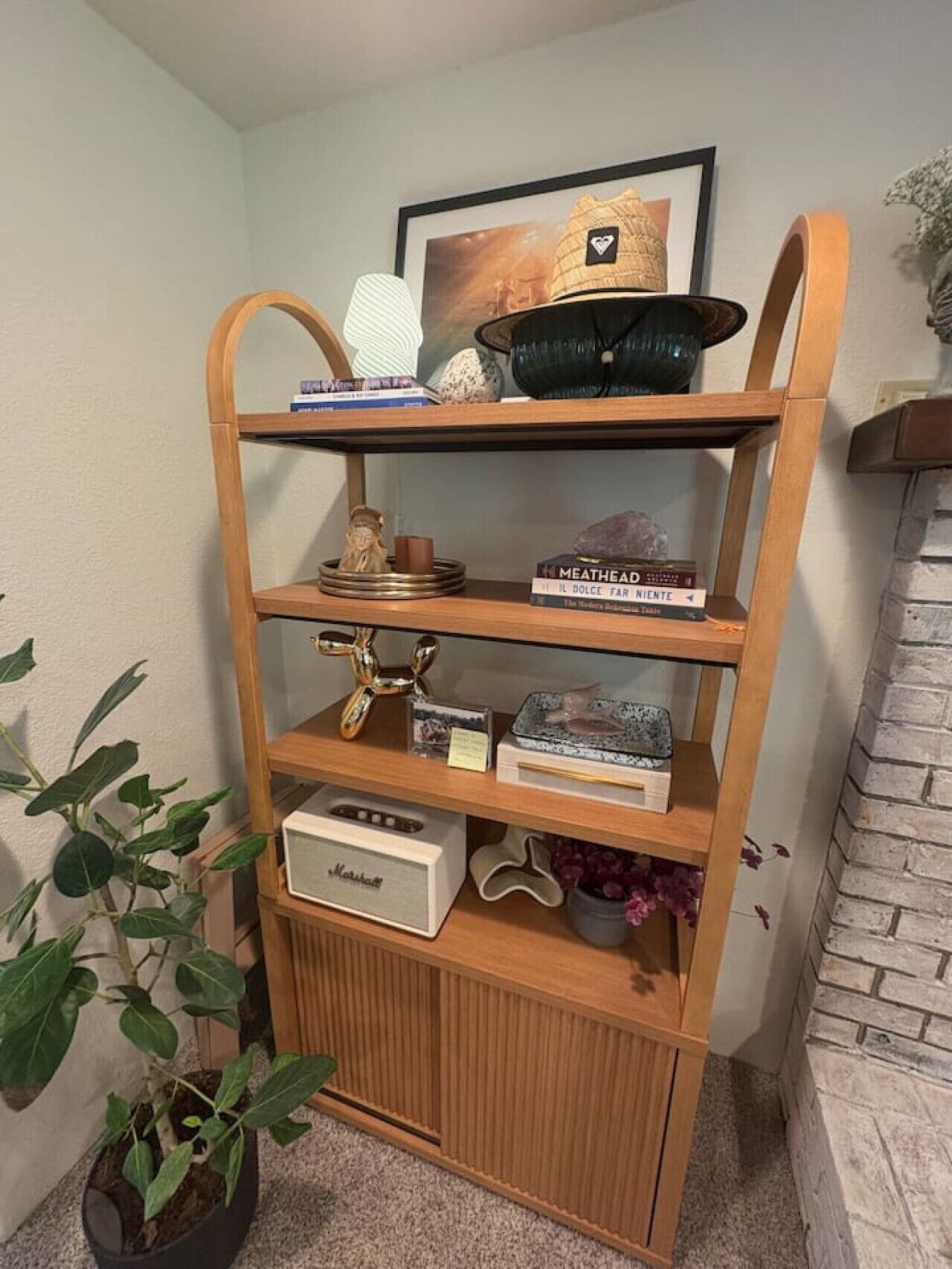 A wooden shelf with books, decorative items, and a vintage radio.