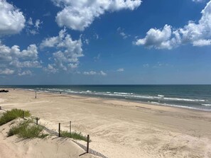 A beach with a clear sky, waves, and a fence. - Shiner by the Sea - Ocean View, Fenced Yard! (Surfside Beach)