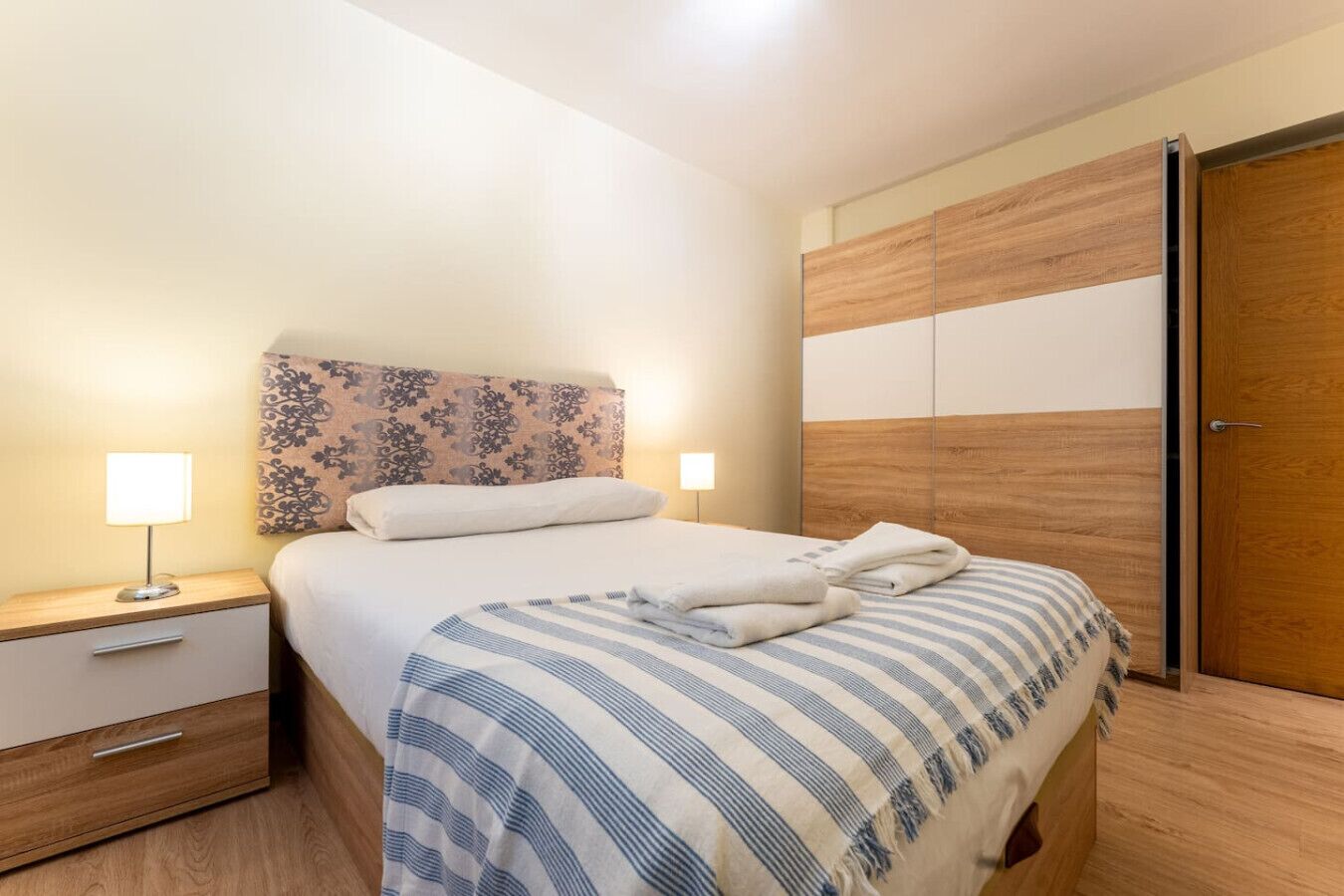 Escritorio, tabla de planchar con plancha, wifi y ropa de cama