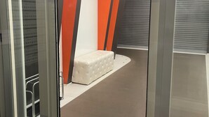 Un ascensor moderno con puertas metálicas y un panel de vidrio.