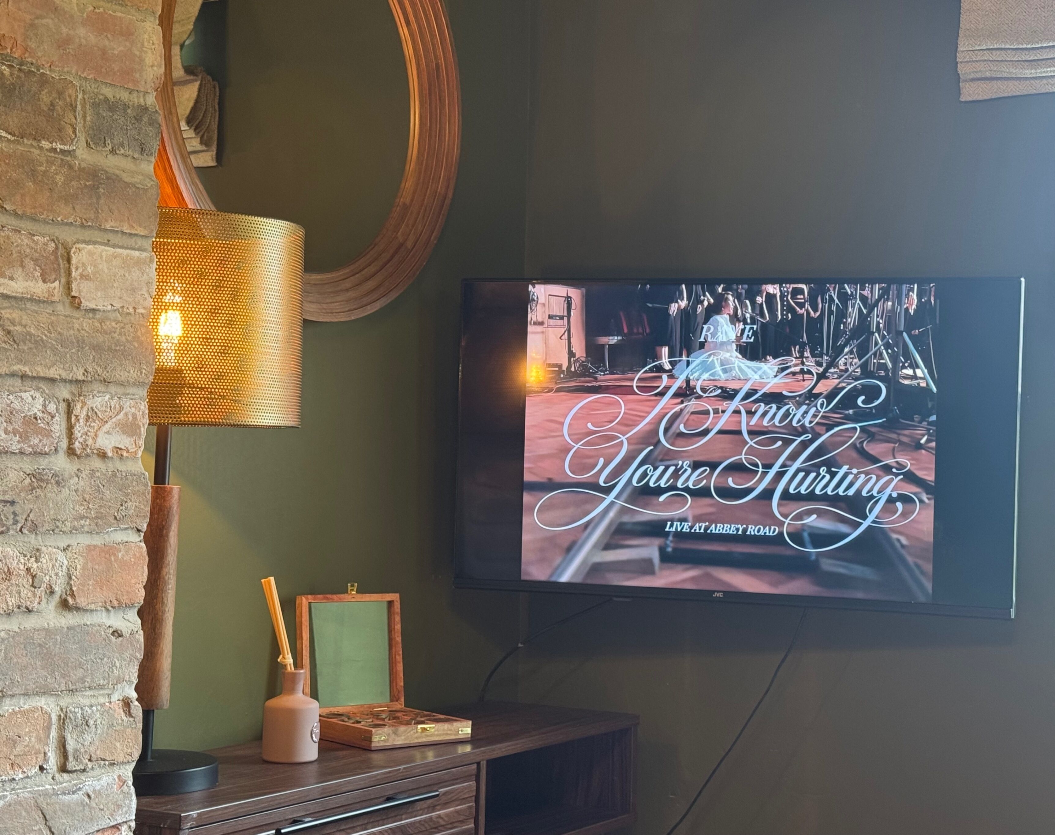 Un televisor en la pared muestra un anuncio de un espectáculo en vivo.