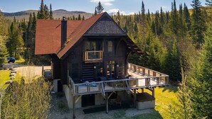A log cabin with a balcony, surrounded by forest. - Spacious family 5 Bedroom Chalet, Hot Tub, pet-friendly, pool lake tennis (Lac-Supérieur)