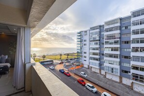 Ein modernes Mehrstöckgebäude mit Parkplatz und Meerblick.