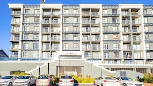 A multi-story residential building with balconies, a nameplate reading 'KEY WEST,' and several parked cars in front. - Key West 314 by CTHA (Cape Town)
