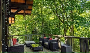 Eine Holzterrasse mit Korbmöbeln und einer Laterne.