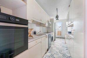 Eine moderne Küche mit Backofen, Mikrowelle und Geschirrspüler.