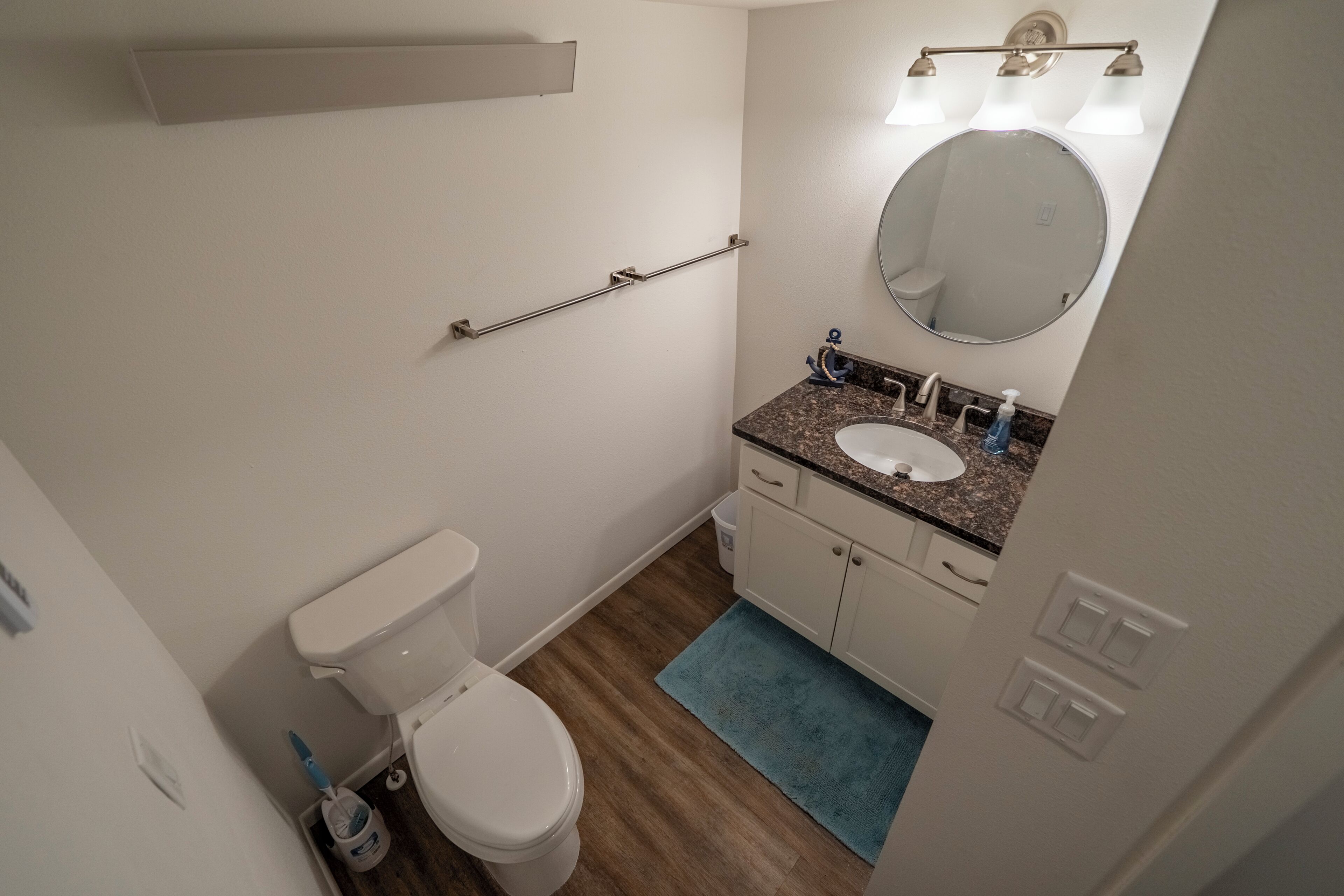Ein Badezimmer mit Toilette, Waschbecken, Spiegel und Handtuchhalter.